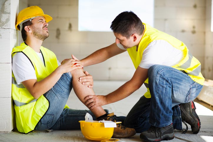 Injured construction worker being attended to by co-worker