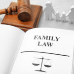Book opened to Family Law page with scale graphic, gavel and block in background
